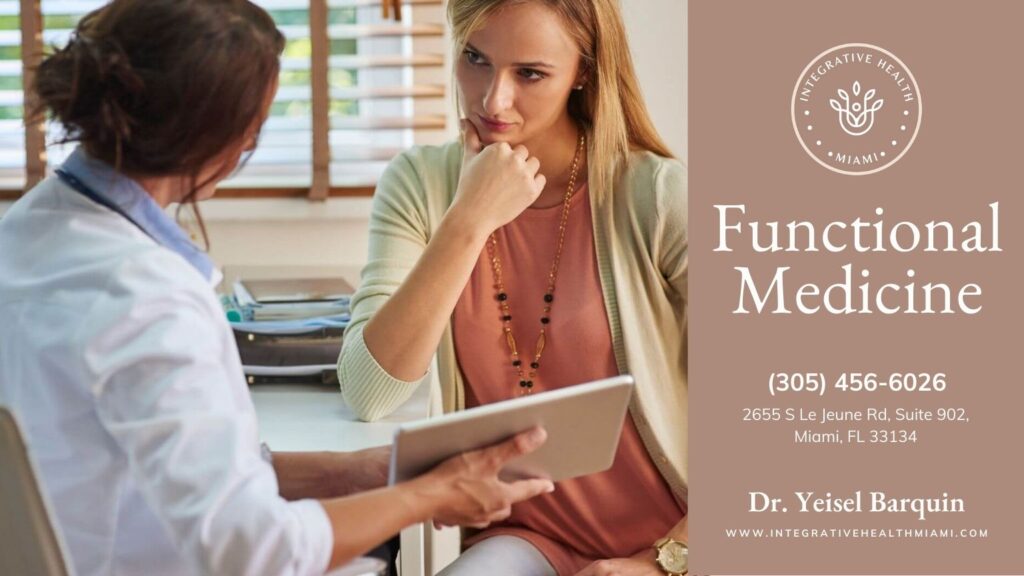 A woman listens intently as a doctor, holding a tablet, explains concepts related to Functional Medicine in a clinic setting.