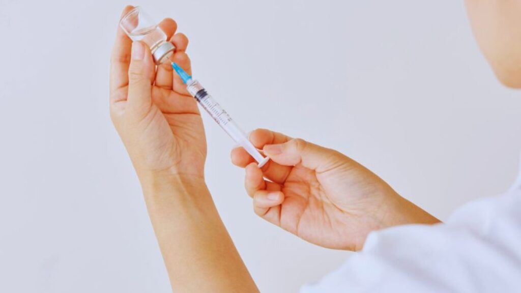 What Are Recovery Peptides And How Do They Work For Healing? 2 Healthcare professional drawing liquid from a vial into a syringe for peptide therapy.