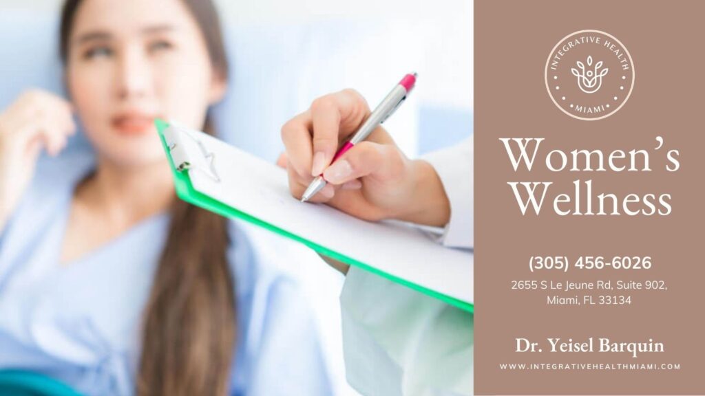 Close-up of a female practitioner taking notes on a clipboard while a patient on a hospital bed actively listens, emphasizing women's wellness consultations.