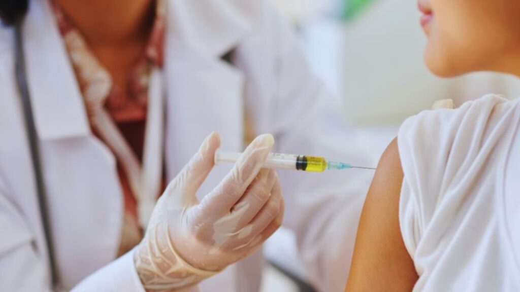 Close-up of a healthcare provider in a white coat giving an injection into a patient’s upper arm, illustrating peptide therapy treatments for anti-aging benefits.