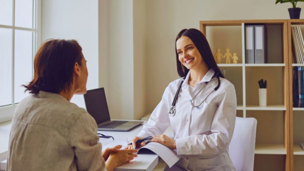 Holistic doctor in Miami meeting with a patient during a one-on-one consultation, discussing personalized treatment options and whole-person health in a welcoming medical office.